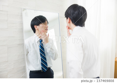 鏡を見る若い男性　 137469808