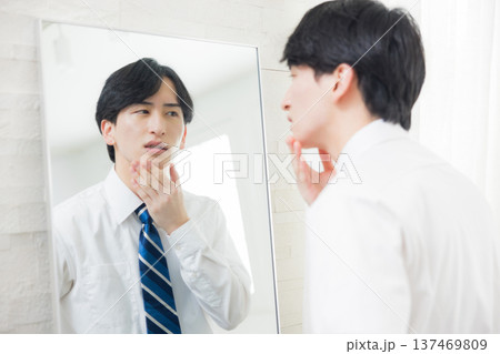 鏡を見る若い男性　 137469809