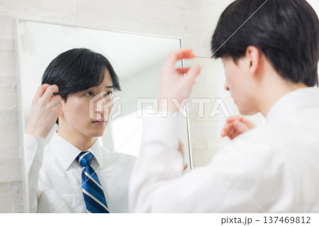 鏡を見る若い男性　 137469812