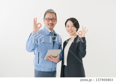 OKポーズをする作業服の男性とスーツの女性 OKポーズをする作業服の男性とスーツの女性 137469863