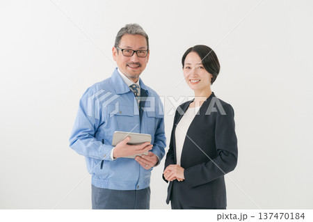 笑顔の作業服の男性とスーツの女性 137470184
