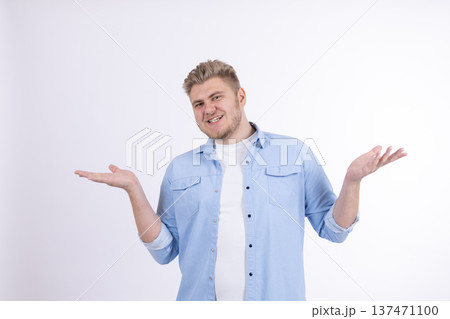 Man in blue shirt shrugging his shoulders in doubt 137471100