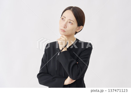 考える喪服を着た女性 白背景 考える喪服を着た女性 白背景 137471123
