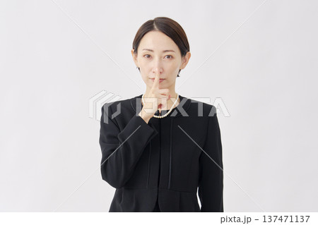 喪服を着た女性 内緒のジェスチャー 白背景 喪服を着た女性 内緒のジェスチャー 白背景 137471137
