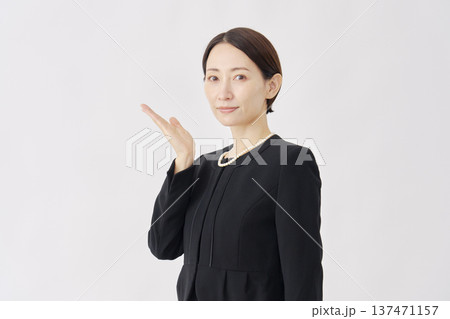 左を手で指す喪服を着た女性　白背景 137471157