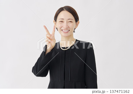 喪服を着た女性　ピースサイン　白背景 137471162