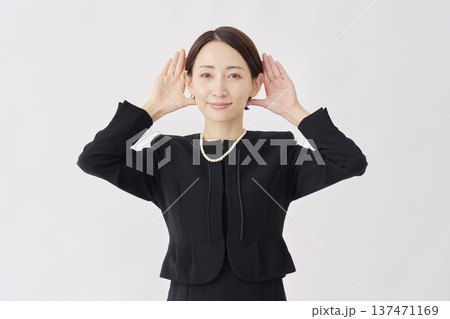 喪服を着た女性　聴くジェスチャー　白背景 137471169