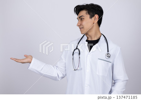 Doctor in white coat presenting something with open hand Doctor in white coat presenting something with open hand 137471185