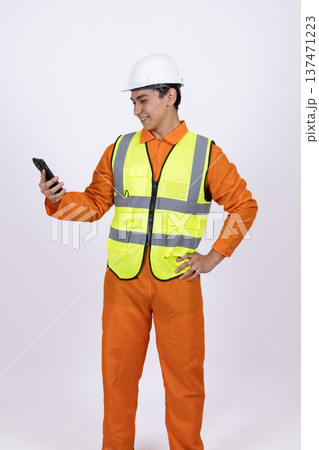 Worker in safety vest using a walkie talkie Worker in safety vest using a walkie talkie 137471223