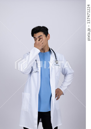 Medical professional in white coat looking thoughtful Medical professional in white coat looking thoughtful 137471224