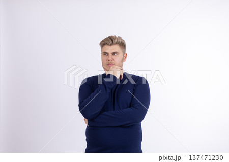 Man in blue sweater with hands on his chin thinking Man in blue sweater with hands on his chin thinking 137471230
