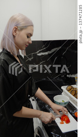 Woman cleaning a black kitchen surface with a sponge Woman cleaning a black kitchen surface with a sponge 137471285