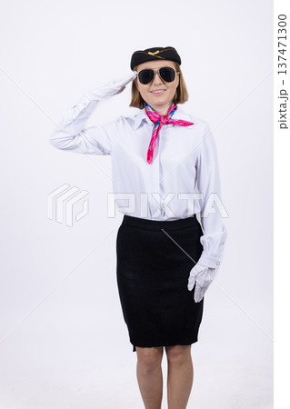 Flight attendant giving a salute in white uniform Flight attendant giving a salute in white uniform 137471300