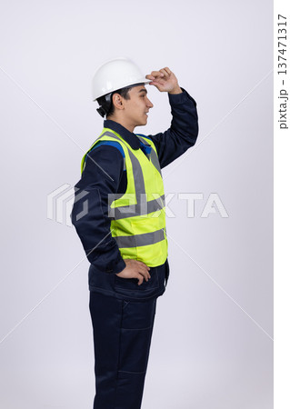 Worker looking away and holding a safety helmet Worker looking away and holding a safety helmet 137471317