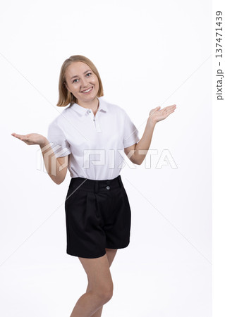 Young woman in white shirt shrugging her shoulders in studio Young woman in white shirt shrugging her shoulders in studio 137471439