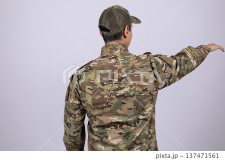 Soldier in military uniform pointing to the side in studio Soldier in military uniform pointing to the side in studio 137471561