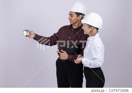 Engineer showing something on smartphone to female colleague Engineer showing something on smartphone to female colleague 137471696