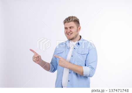 Man in blue shirt pointing to the side with one hand Man in blue shirt pointing to the side with one hand 137471748