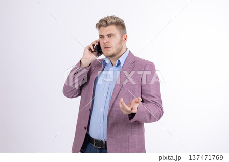 Stylish man in pink blazer talking on mobile phone in studio Stylish man in pink blazer talking on mobile phone in studio 137471769