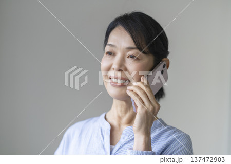 スマートフォンで通話する笑顔の50代後半の女性 137472903