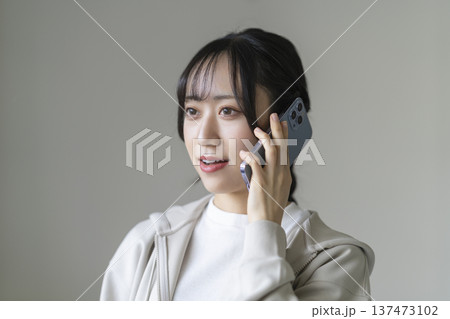 スマートフォンで通話する笑顔の若い女性 137473102