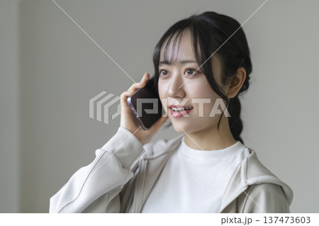 スマートフォンで通話する笑顔の若い女性 137473603