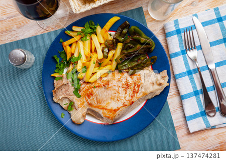 Baked pork with french fries and baked green pepper 137474281
