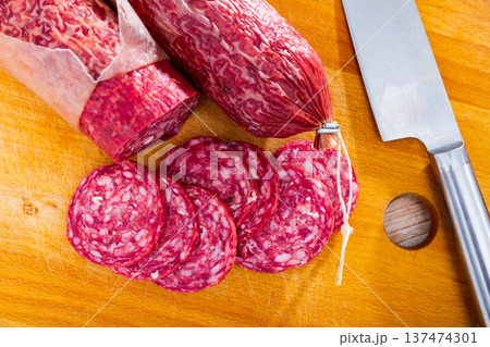 Sliced Iberian dry cured pork sausage salchichon on wooden background Sliced Iberian dry cured pork sausage salchichon on wooden background 137474301