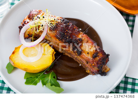 Grilled pork ribs with chocolate sauce and baked potatoes 137474368