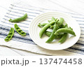 白皿に乗せたスナップエンドウと割ったさや 137474458