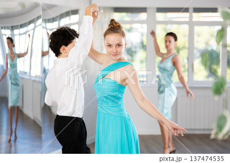Couple of teenagers in evening dresses are learning to dance an polonaise dance 137474535