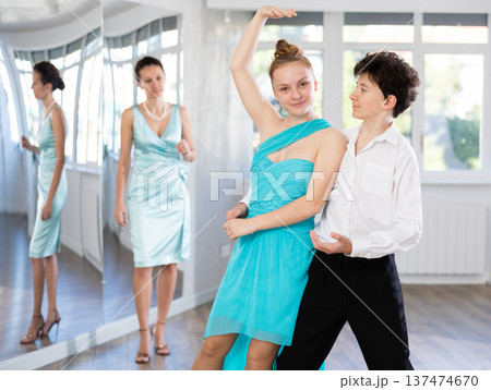 Teenage girl and boy practicing waltz in dance hall with female mentor Teenage girl and boy practicing waltz in dance hall with female mentor 137474670