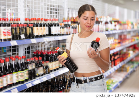 Young woman choosing soy sauce in store 137474928
