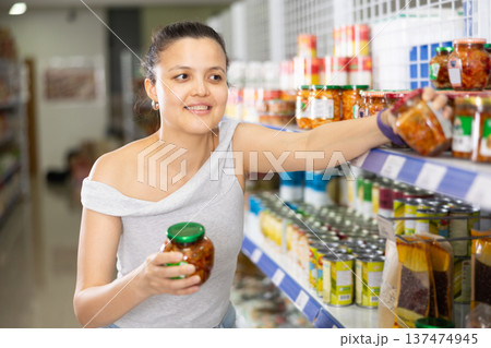 Young woman chooses mustard in store 137474945