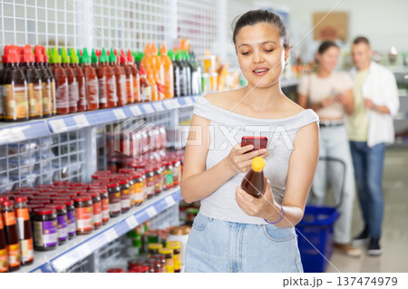 Woman looking for chili sauce using code on internet Woman looking for chili sauce using code on internet 137474979