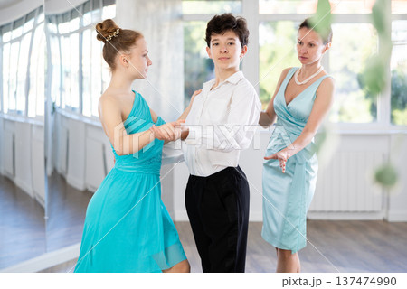 Dance teacher teaches a girl and a boy couples ballroom dancing Dance teacher teaches a girl and a boy couples ballroom dancing 137474990