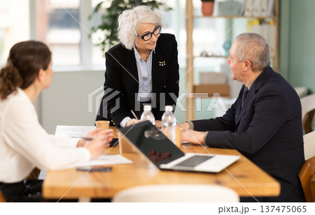 Senior business community listening to female speaker or presenter during round table conference. 137475065