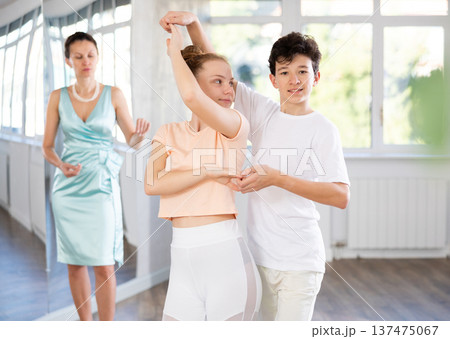 Motivated adolescent ballroom dancers practicing dance moves in studio 137475067