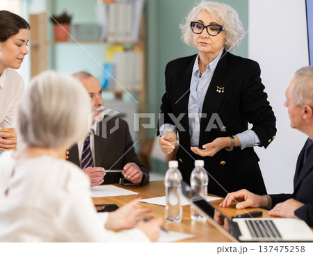 Woman manager holding business meeting with colleagues at table in office 137475258