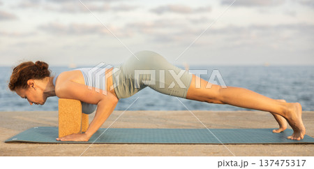 Female yoga instructor performing various asana poses using rectangular blocks 137475317