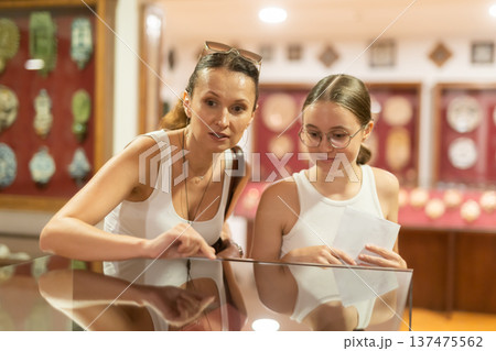 Woman and teenage girl looking at exhibit in museum display 137475562