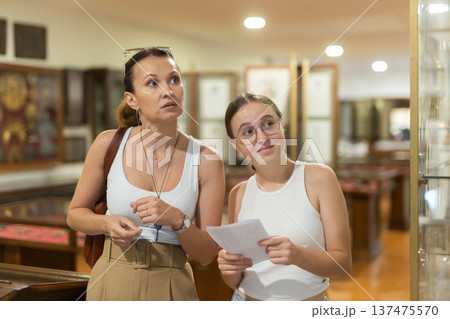 Woman and teenage girl looking at exhibit in museum 137475570