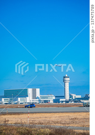 青空の下を飛ぶ飛行機と新千歳空港の風景（北海道千歳市） 137475789