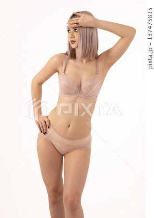 Beautiful woman posing in beige set against white background Beautiful woman posing in beige set against white background 137475815