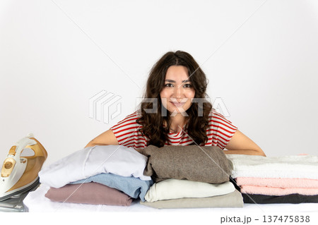 Woman with messy laundry pile looking at camera 137475838