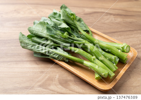 Fresh Chinese kale or Chinese broccoli (Gai Lan) on wooden tray, prepared for cooking Fresh Chinese kale or Chinese broccoli (Gai Lan) on wooden tray, prepared for cooking 137476389