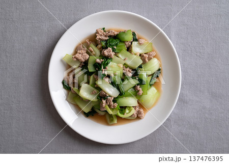 Stir-fried bok choy and minced pork with soy sauce (Thai food) on white plate, Top view 137476395