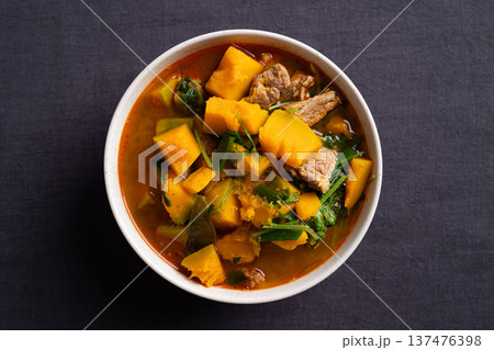 Thai spicy pumpkin curry soup with pork in a bowl on black background Thai spicy pumpkin curry soup with pork in a bowl on black background 137476398