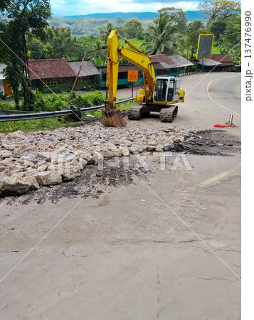 repair of collapsed road using excavator heavy equipment 137476990