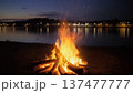 湖畔で燃える焚き火の夜景｜アウトドアキャンプの暖かい炎 137477777